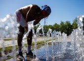 Un peatón en una fuente pública se vierte agua en la cara en un día caluroso en Berlín, Alemania, este miércoles 2 de julio de 2025.
