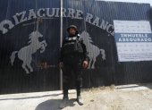 Integrante de la fiscalía estatal resguardando la entrada al Rancho Izaguirre en el municipio de Teuchitlán, Jalisco (México).