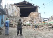 Personas observan este miércoles una edificación destruida por los temblores ocurridos el martes, en Santa María de Jesús (Guatemala).