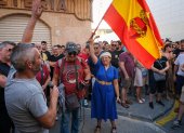 Una mujer con una bandera de España con el sagrado corazón de Jesús en la concentración de este 15 de julio de 2025, en Torre Pacheco (Murcia).
