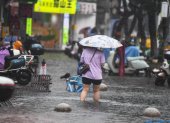 Un peatón camina a través de una zona inundada en Haikou, provincia de Hainan, China, el 20 de julio de 2025.