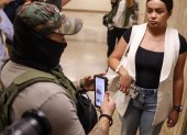 Un agente federal usa información en su teléfono mientras detiene a una mujer fuera de las audiencias del tribunal de inmigración Nueva York, Nueva York, EE. UU..