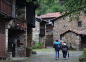 Turismo. Una pareja de visitantes da un paseo por un pintoresco pueblo rural de España para adentrarse en el agroturismo que los atrajo.