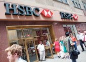 La gente camina por delante de una de las sucursales del Banco HSBC.