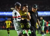 Un jugador de Sao Paulo lleva en sus brazos a Joao Rojas, tras su lesión en el partido ante Barcelona en Copa Libertadores.