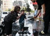 Calor. Las personas pausan su paso para refrescarse con agua en la calle.