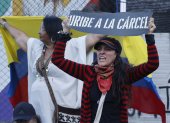 Una detractora del expresidente de Colombia, Álvaro Uribe, sostiene un cartel frente al Complejo Judicial de Paloquemao este lunes, en Bogotá (Colombia). El "juicio del siglo" en Colombia partió en dos la historia judicial del país al imponer en primera instancia una condena a 12 años de prisión y otras sanciones al expresidente Álvaro Uribe (2002-2010), quien consideró "sesgado" el proceso y la sentencia de la jueza Sandra Heredia. EFE/ Mauricio Dueñas Castañeda