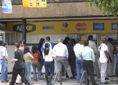 Personas realizan transacciones bancarias en cajeros automáticos en el Banco Pichincha.