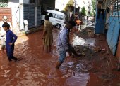La gente camina entre los escombros de la calle inundada tras varios días de fuertes lluvias en Islamabad, Pakistán, el 6 de agosto de 2025.