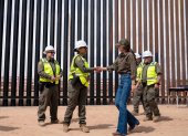 Secretaria de Seguridad Nacional de Estados Unidos, Kristi Noem saludando a un funcionario en frente del muro fronterizo entre Estados Unidos y México.