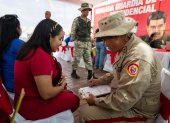 Un funcionario de la Milicia Bolivariana de Venezuela registra a una mujer durante una jornada de alistamiento este sábado, en Caracas (Venezuela).