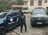 Oficial haciendo guardia afuera de una casa durante una operación dirigida a una red de lavado de dinero en Sao Paulo, Brasil, el 28 de agosto de 2025