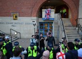 Un manifestante (arriba en el centro) es arrestado poco después de intentar colgar una bandera de la Unión afuera de las oficinas del consejo en Epping, al noreste de Londres.