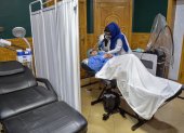 Un miembro del personal médico realiza un tratamiento con láser en el rostro de una mujer afgana en una clínica de belleza en Kabul.