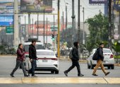 Personas caminan por una calle durante una jornada de paro de transportadores en la ciudad de Lima (Perú).