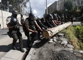 Policías retiran un tronco de la carretera, que fue puesto por los que quieren que el diésel tenga subsidio.