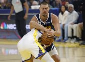 Nikola Jokic (detrás) fue la estrella de Nuggets en su debut ganador.