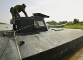 Fotografía de un soldado de la Armada Nacional de Colombia al inspeccionar un submarino utilizado por grupos delictivos.