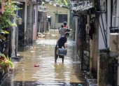 Personas afectadas por las inundaciones en Sri Lanka limpian su casa cubierta de barro y agua, el 3 de diciembre de 2025.