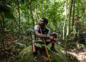 Un hombre maniq descansando en una roca y comiendo fruta silvestre, durante una expedición de caza en Phatthalung, en el sur de Tailandia.