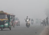 Vehículos transitan por calles en Nueva Delhi con poca visibilidad debido a la contaminación del aire en India.