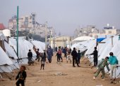 La gente camina entre los refugios en el campamento de Nuseirat para palestinos desplazados en el centro de la Franja de Gaza el 22 de diciembre de 2025.