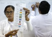 Funcionarios electorales de Myanmar cuentan las papeletas de votación en la primera fase de las elecciones generales en la capital de Myanmar, el 28 de diciembre de 2025.