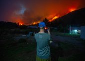 Un hombre toma una fotografía de los incendios forestales este miércoles, en el Hoyo provincia de Chubut (Argentina).