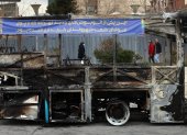 Iraníes caminan cerca de los restos de un autobús público incendiado en Teherán, Irán, el 15 de enero de 2026.