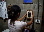 Jade, de 16 años, sostiene una fotografía de su padre, José Roger Urquilla, en su casa en El Rosario, El Salvador, el 3 de diciembre de 2025.