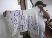 Un hombre desplazado por la violencia mostrando una camiseta con una nota escrita pidiendo paz para el Catatumbo en Cúcuta (Colombia).