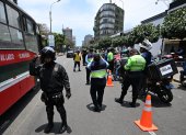 Agentes policiales registran a motociclistas en un puesto de control después de que el gobierno declarara el estado de emergencia en Lima.