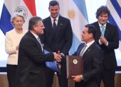 El Comisario de Comercio y Seguridad Económica; Relaciones Interinstitucionales y Transparencia de la Comisión Europea, Maroš Šefčovič (i) y el ministro de Relaciones Exteriores de Paraguay, Rubén Ramírez (d), se saludan sosteniendo los documentos del acuerdo de libre comercio firmados entre la Unión Europea (UE) y los países del Mercosur este sábado, en Asunción (Paraguay). El Mercosur y la Unión Europea (UE) firmaron un histórico acuerdo de libre comercio que dará lugar a una de las mayores zonas integradas del mundo, con 720 millones de personas, tras 26 años de negociaciones. EFE/ Juan Pablo Pino