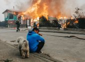 Un hombre observa casas afectadas por incendios forestales este domingo, en Penco (Chile).