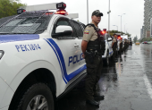 Policías permanecen junto a patrulleros durante un operativo de seguridad en Quito.