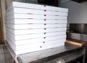 Cajas de pizza en la cocina de un establecimiento clausurado por Arcsa.