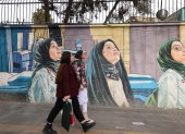 Mural. Mujeres pasan frente a un mural representativo, en Tehran.