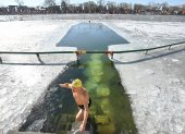 Un entusiasta de la natación invernal hace un gesto después de nadar en el lago Houhai del área escénica de Shichahai en Beijing el 20 de enero de 2026.