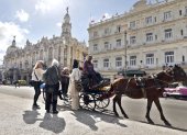 Fotografía del 29 de enero de 2026 que muestra a turistas montando en un coche alado por un caballo en La Habana (Cuba).