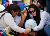 Personas lloran durante una protesta alrededor de El Helicoide este sábado 7 de febrero, en Caracas (Venezuela).