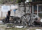 Un policía israelí inspecciona los restos de un vehículo incendiado después de que Israel interceptara un misil balístico de Irán, este domingo 15, en Tel Aviv.