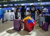 Un grupo de pasajeros alistan documentos en el aeropuerto.