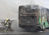 Un integrante del Cuerpo de Bomberos de Guadalajara intenta apagar un vehículo incendiado este domingo 22 de febrero, en esa ciudad mexicana.