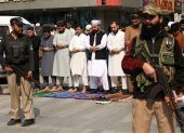 Oficiales de seguridad y musulmanes civiles en una calle de Peshawar, en Pakistán.