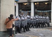 Integrantes de la Policía de Argentina se cubren durante un enfrentamiento con manifestantes por la reforma laboral, en Buenos Aires (Argentina).