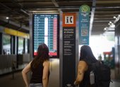 Dos pasajeras observan una pantalla informativa que muestra los vuelos cancelados en el Aeropuerto Internacional Jorge Newbery de Buenos Aires.