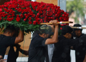 Integrantes del cortejo fúnebre trasladan un arreglo de rosas rojas durante el sepelio de ‘El Mencho’, en medio de un fuerte operativo en Jalisco.