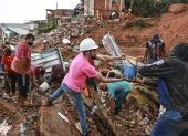 Personas ayudan en labores de rescate y remoción de escombros en una zona afectada por fuertes lluvias este martes, en Juiz de Fora (Brasil).