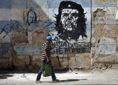 Una persona camina frente a un mural con la imagen de Ernesto 'Che' Guevara este jueves, en una calle de La Habana (Cuba).