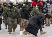 Un integrante de la Policía detiene a una persona durante las protestas en Mineápolis contra el Servicio de Inmigración y Control de Aduanas (ICE).